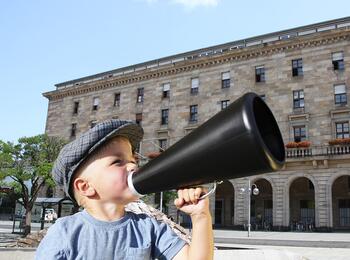 Kind mit Megaphone vor dem Rathaus