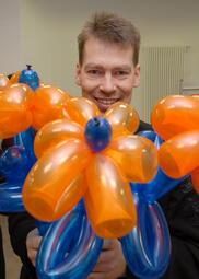 Vergrößerte Ansicht von Zauberkünstler Andreas Knecht mit einer Blume aus Luftballons