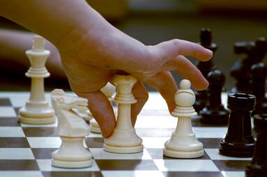 Vergrößerte Ansicht von Kinderhand, die Schach spielt