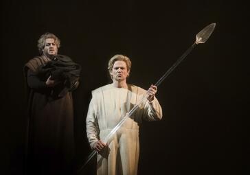 Vergrößerte Ansicht von Jonathan Stoughton (Parsifal) mit Speer, im Hintergrund Patrick Zielke (Gurnemanz)
