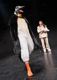 Vergrößerte Ansicht von Eine Person trägt ein Pinguin-Kostüm. Soyi Cho steh dahinter mit Fellweste.