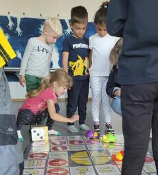 Vergrößerte Ansicht von Kinder spielen auf einem Spielteppich mit einem Bienen-Roboter.