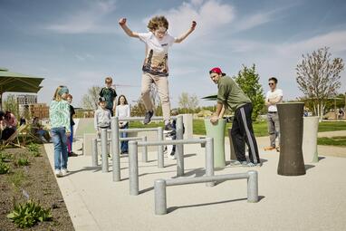 Vergrößerte Ansicht von Kind springt über Hürden. Parkour-Anlage in der Parkschale Käfertal, Spinelli-Park, Mannheim