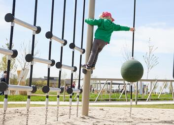 Vergrößerte Ansicht von Kind klettert in einem Netz. Spielplatz in der Parkschale Käfertal, Spinelli-Park, Mannheim