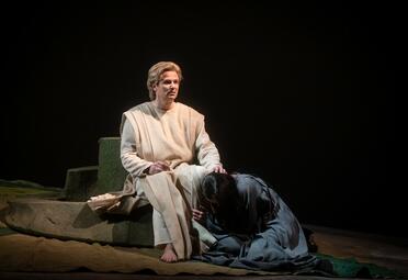 Vergrößerte Ansicht von Julia Faylenbogen (Kundry) liegt zusammengekauert zu Jonathan Stoughtons (Parsifal) Füßen