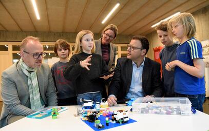 Vergrößerte Ansicht von Schüler aus der Lego-AG der Franklinschule erklären den Bürgermeistern, wie sie ihre bunten Bausteine digital steuern.